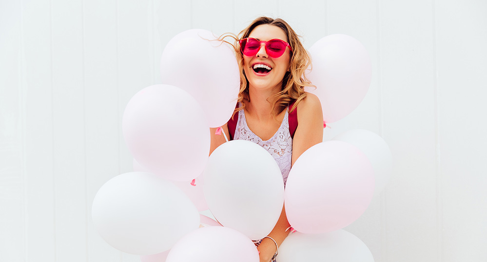 Cheerful girl having fun while holding balloons