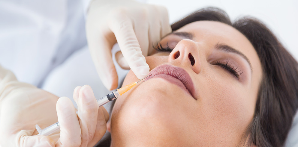 Beautiful young woman getting botox cosmetic injection in her face